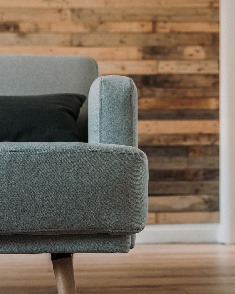 Wand van houten planken achter een fauteuil